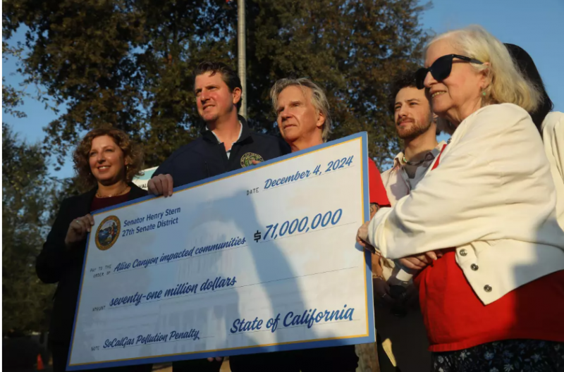 California Assemblywoman Pilar Schiavo, from left, California Senator Henry Stern, Matt Pecucko with Save Porter Ranch, Amadeo Feingold with Climate Resolve and Patty Glueck, right, with Aliso Moms Alliance, hold a $71-million settlement check presented to members of the communities affected by the Alison Canyon Well Failure in front of the Southern California Gas Company in Chatsworth on Wednesday. (Genaro Molina/Los Angeles Times)